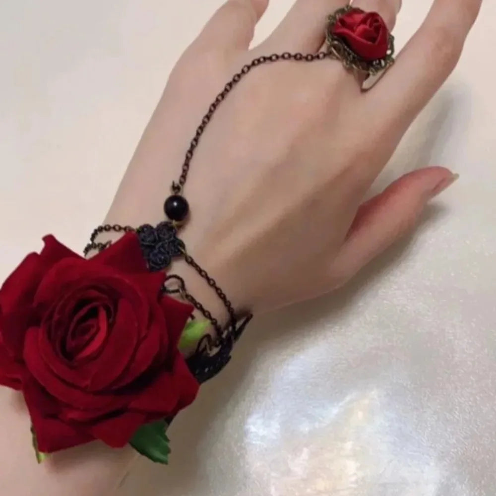Red rose charm bracelet on black chain with dangling bead and small black pendant