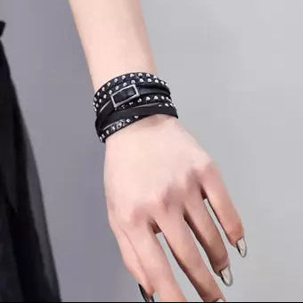 Black studded wrap bracelet with silver buckle on wrist