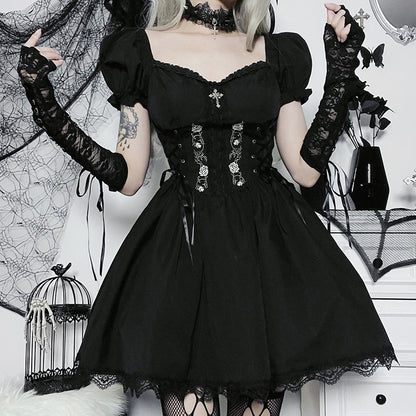Person wearing a black gothic dress with lace details in a decorative setting.