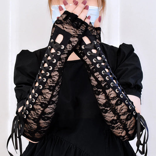 Black lace fingerless wrist cuffs with ribbon laces, worn with dark outfit
