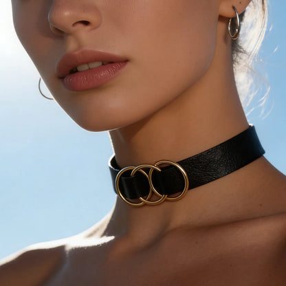 Black leather choker with three gold-tone interlocking rings, front view