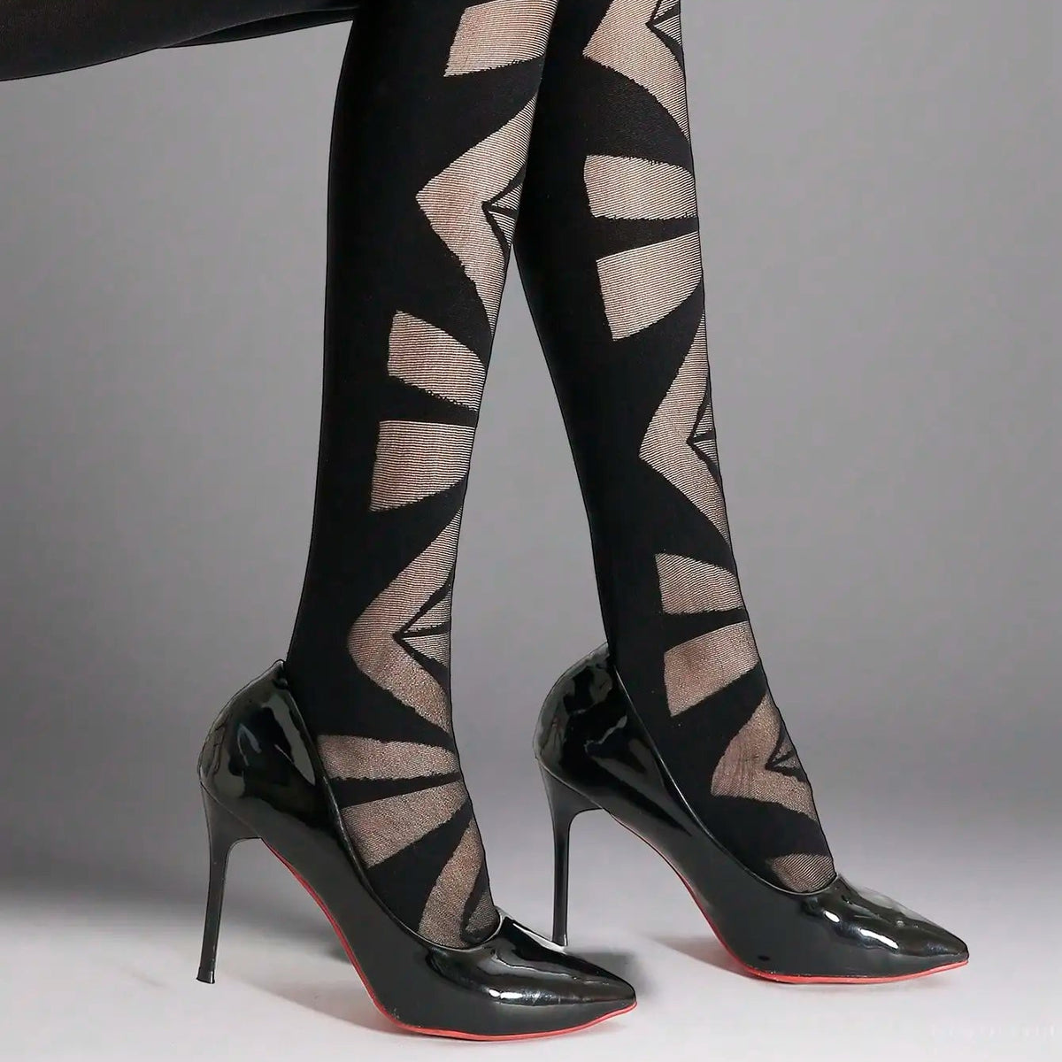 Black sheer tights with abstract geometric nude pattern, paired with patent pumps