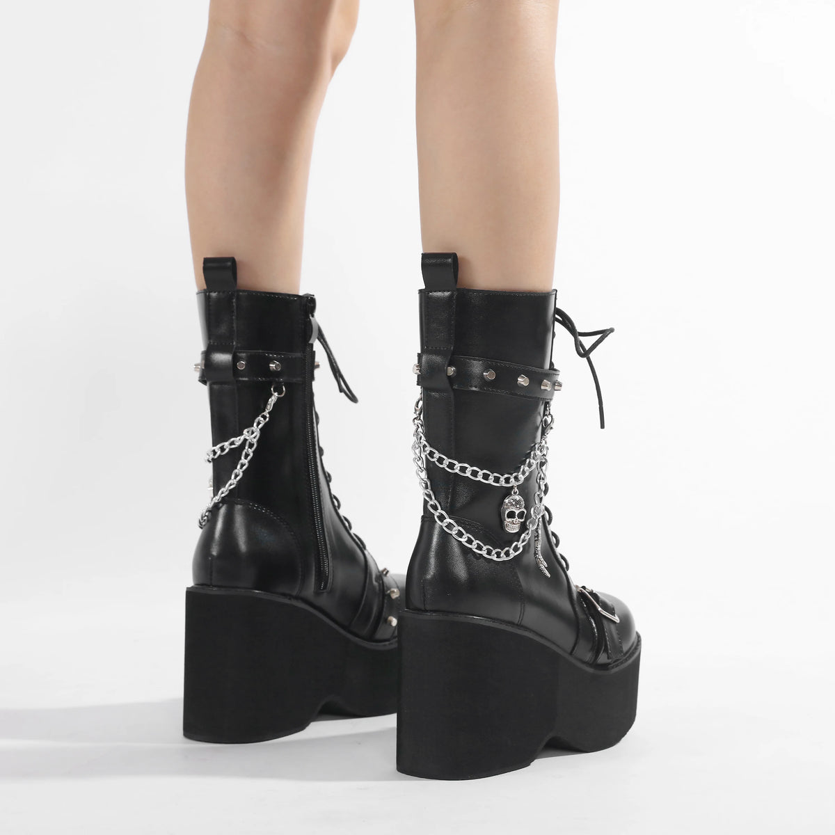 Black platform ankle boots with lace-up ties, buckle straps, and silver chain accents