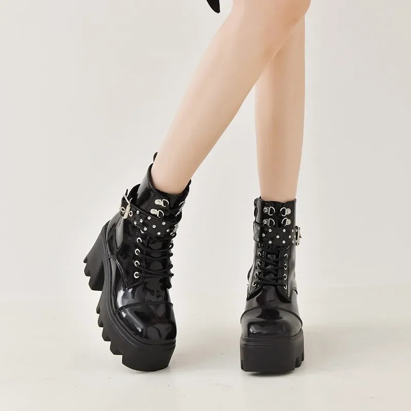 Black glossy lace-up boots with studded cuff straps and thick tread sole