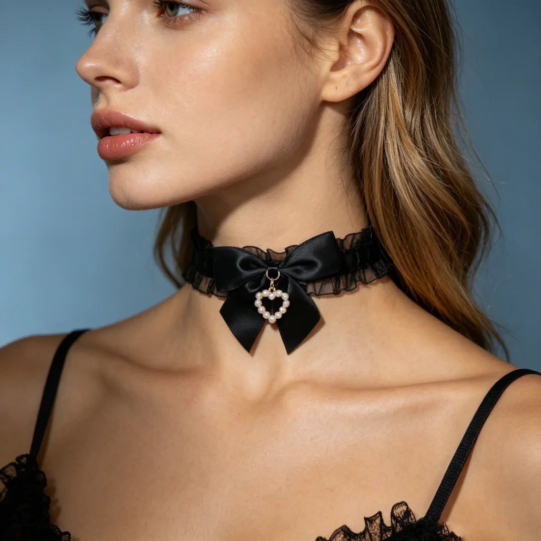 Black satin choker with ruffled trim, bow, and heart pearl pendant