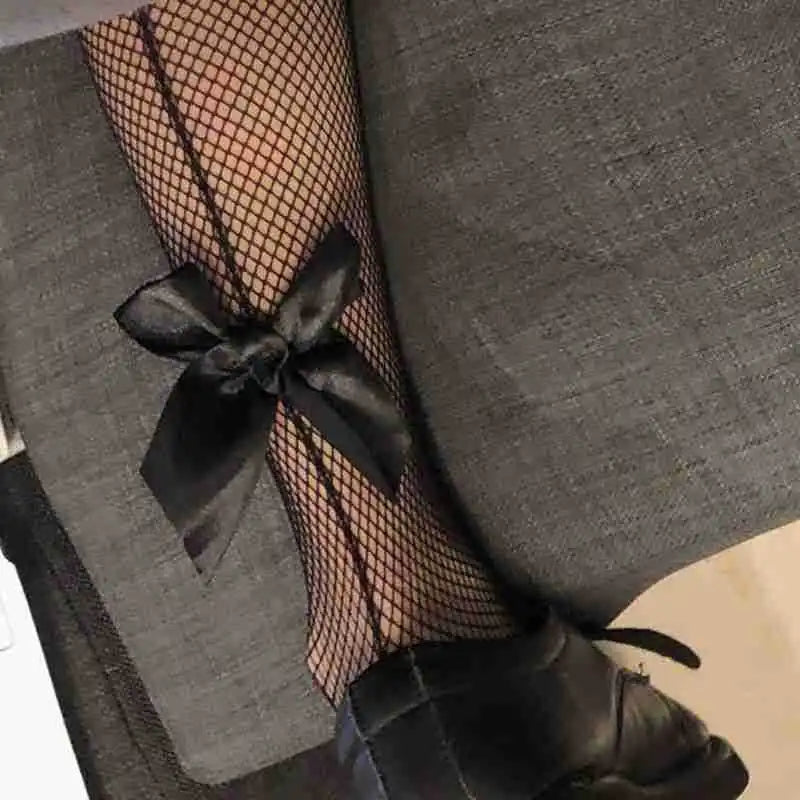 Black fishnet stockings with layered ribbon bow garter detail