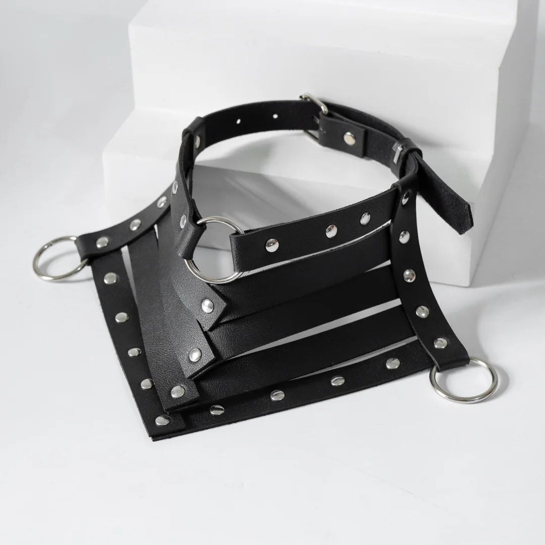 Black leather neck harness with silver studs, crisscross straps and metal O-rings