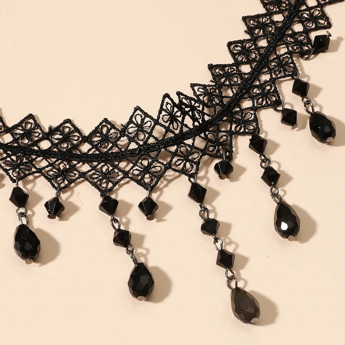Black lace choker close-up with faceted teardrop crystal drops