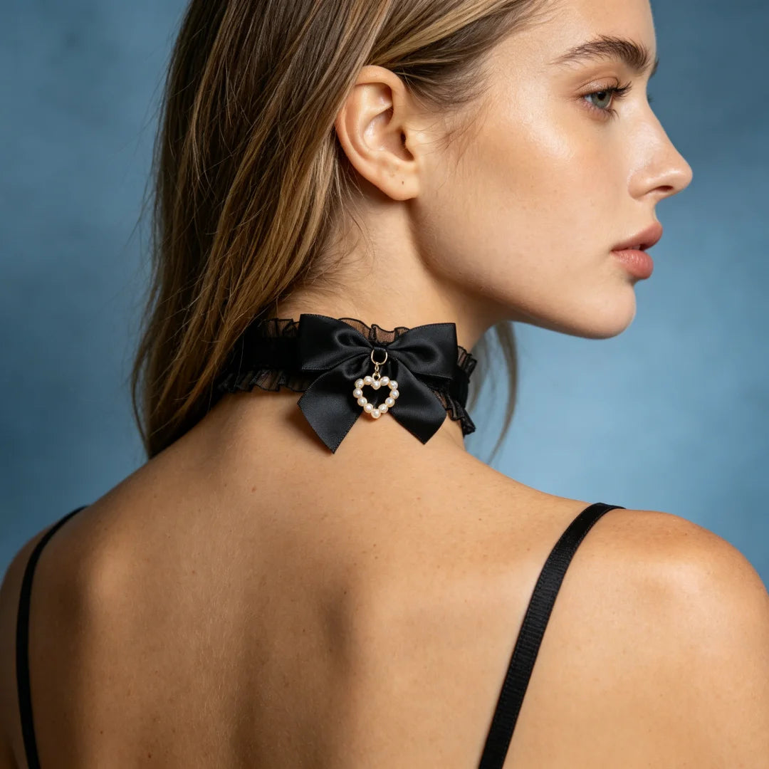 Black satin bow choker with ruffled edge and heart-shaped pearl charm