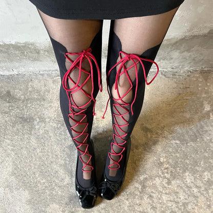 Black thigh-high boots with red lace-up front and glossy pointed toe tips