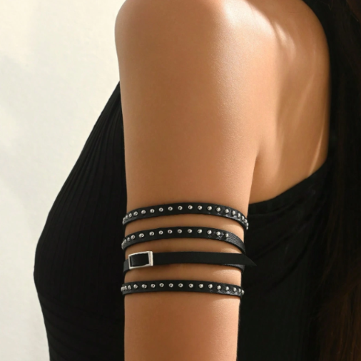 Black studded multi-wrap bracelet with silver buckle on upper arm