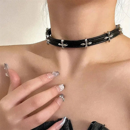 Black leather choker collar with silver cross studs, worn at the neck