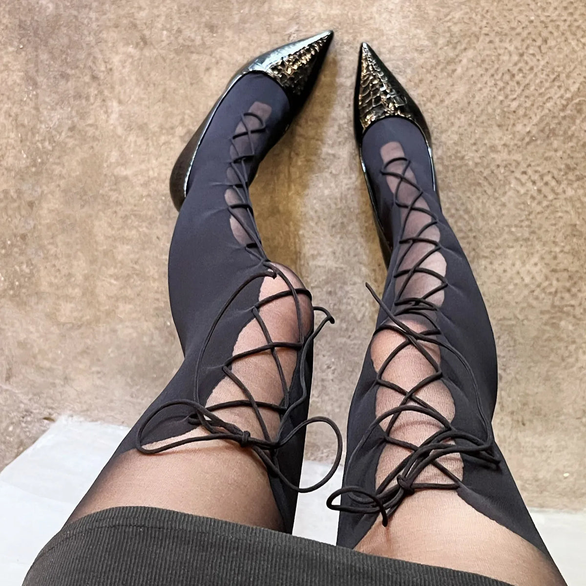 Black lace-up pointed-toe boots with glittery heel tips and tall slim profile