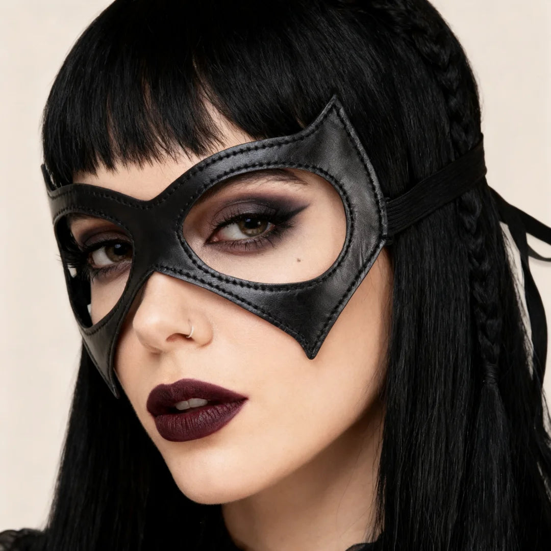 Black cat-eye masquerade mask with pointed nose bridge, worn on face, elastic strap