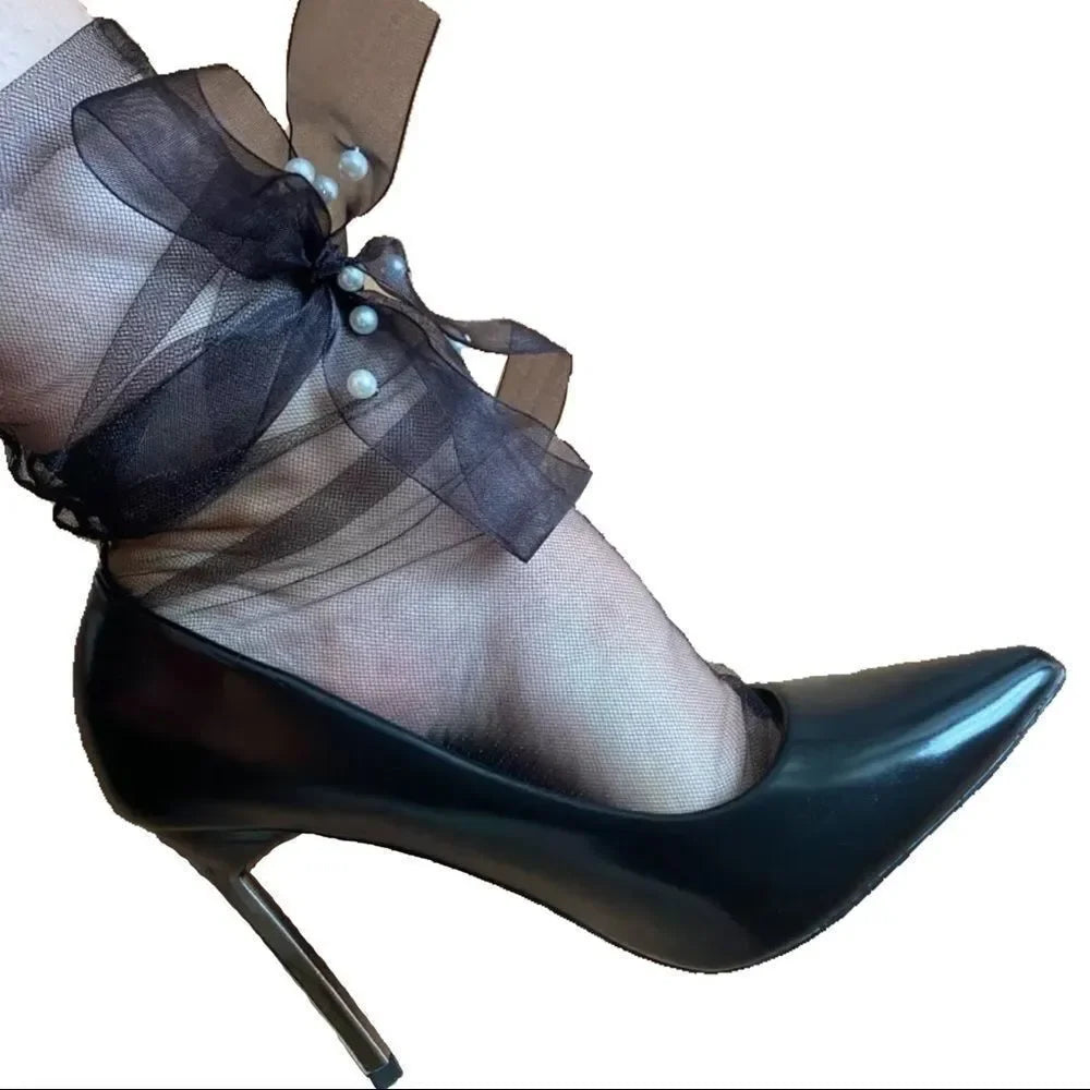 Sheer mesh sock detail with black bow, pearl beads, and high-heel shoe
